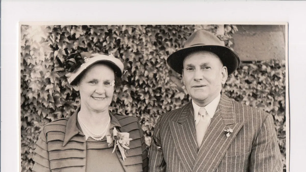 Oud zwart-wit portret van een ouder koppel met hoeden en een corsage