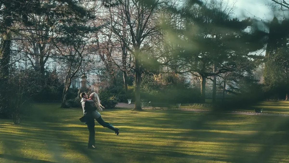 Koppel in de verte in een park, van op afstand door het groen heen gefotografeerd