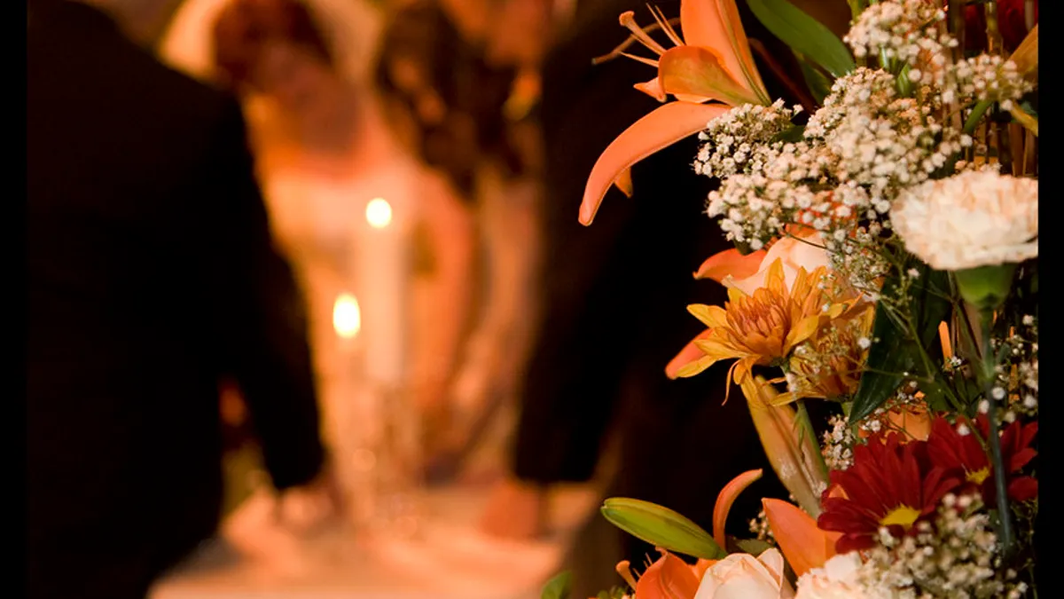 Sfeerbeeld van een huwelijksviering met bloemen en kaarslicht