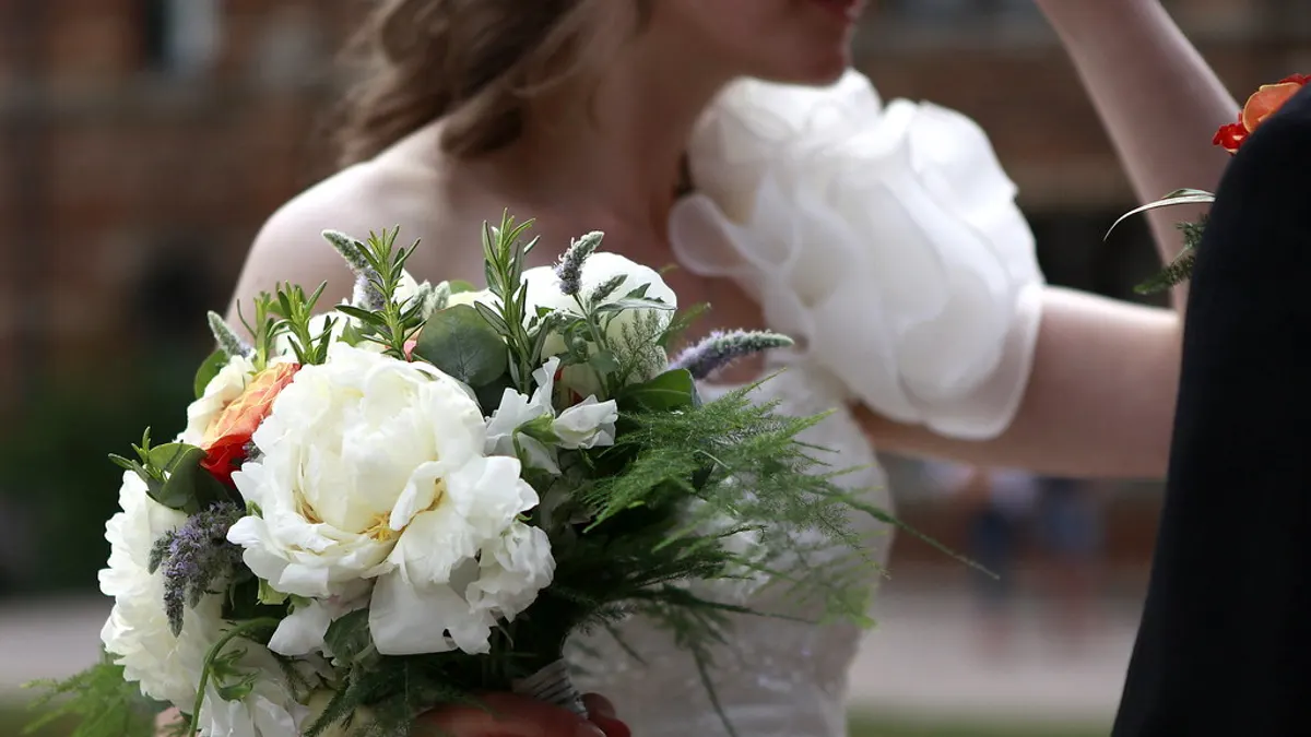 Bruid houdt een romantisch bruidsboeket met seizoensbloemen vast