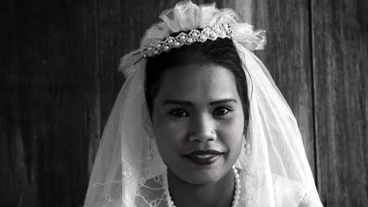 Zwart-witportret van een bruid met een parelen diadeem en een tulen sluier over haar donkere haar