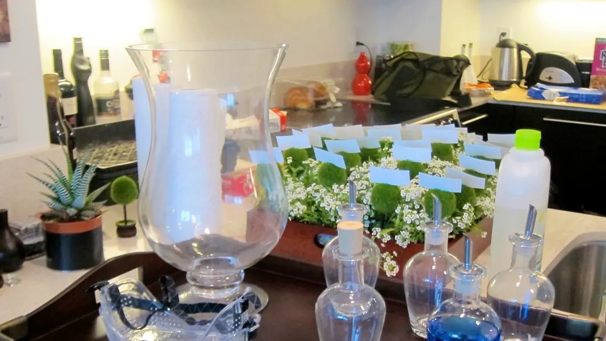 Keukenaanrecht vol vazen, flessen en naamkaartjes met bloemen als voorbereiding