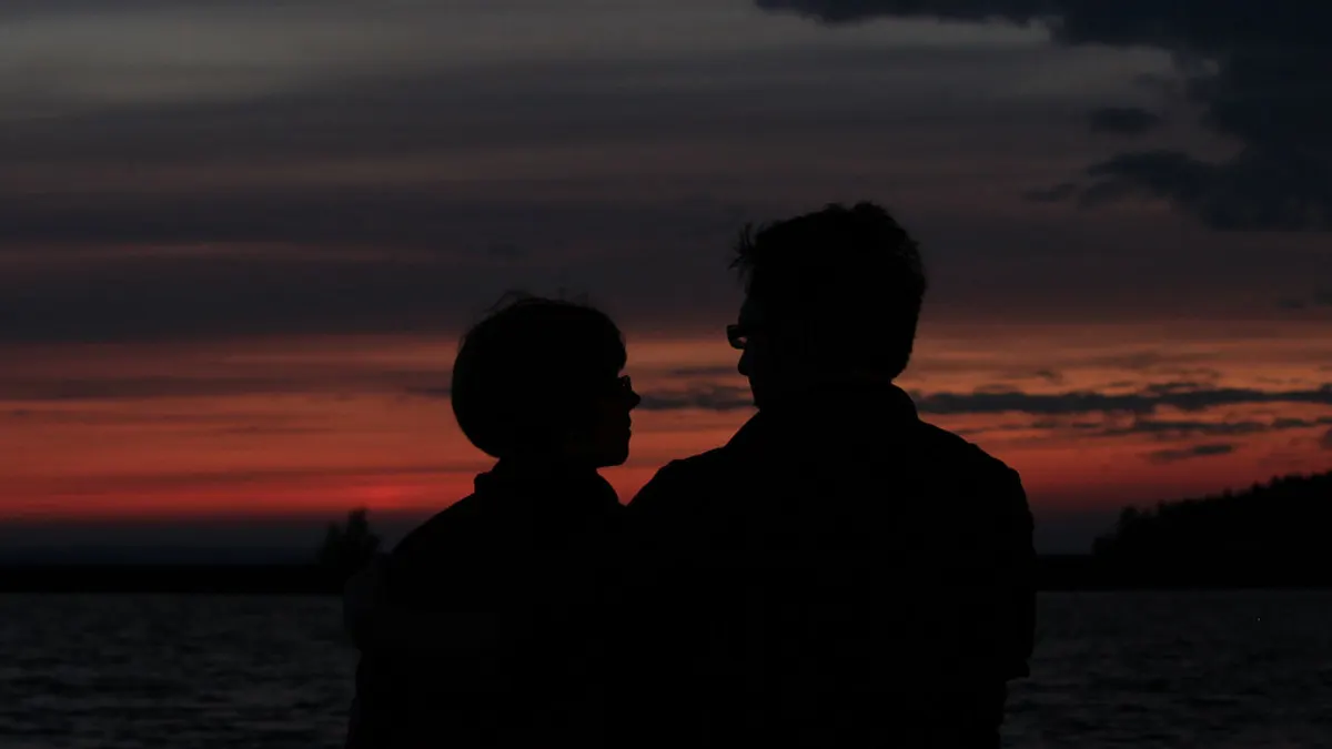Silhouet van een koppel tegen een rode lucht bij zonsondergang