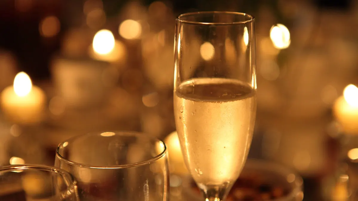 Collega's proosten met een glas bubbels tijdens de receptie van een bruiloft