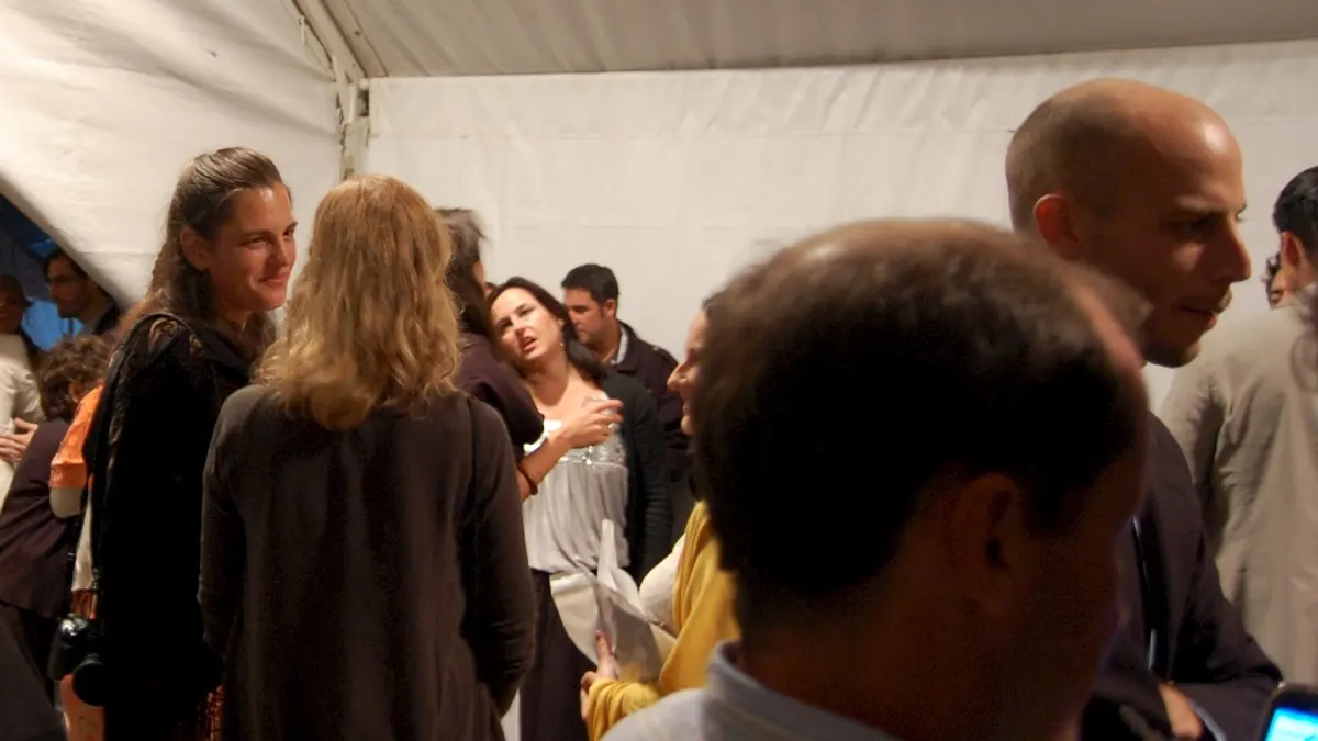 Gasten staan dicht bij elkaar en omhelzen elkaar in een witte feesttent