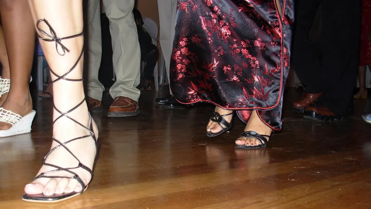 Voeten van dansende gasten in feestschoenen op een glanzende houten dansvloer
