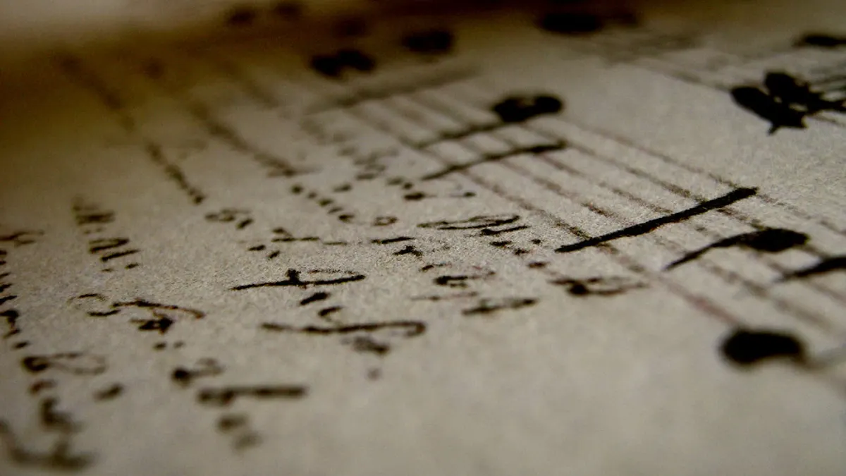 Handgeschreven noten en tekst op een vel muziekpapier in close-up