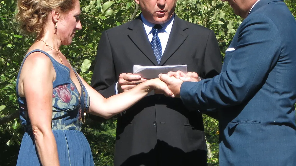 Iemand schrijft met de hand trouwbeloften in een klein boekje