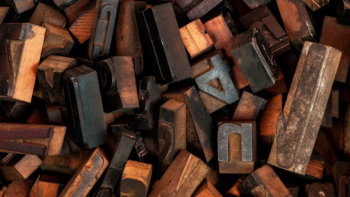 Een hoop oude houten drukletters in verschillende lettertypes