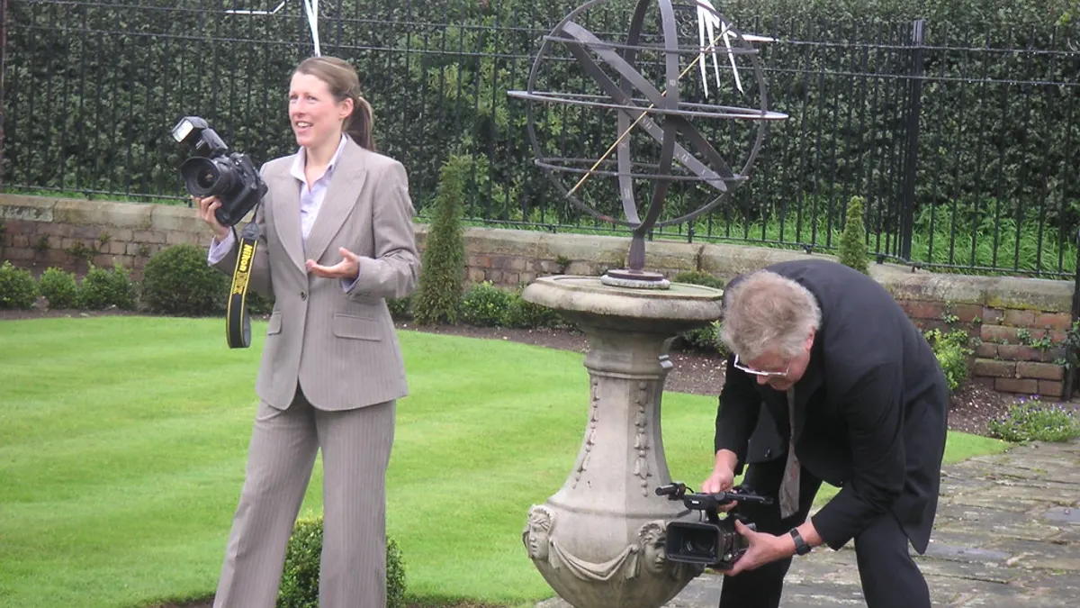 Fotografe met camera en een videograaf die laag filmt werken samen in een tuin