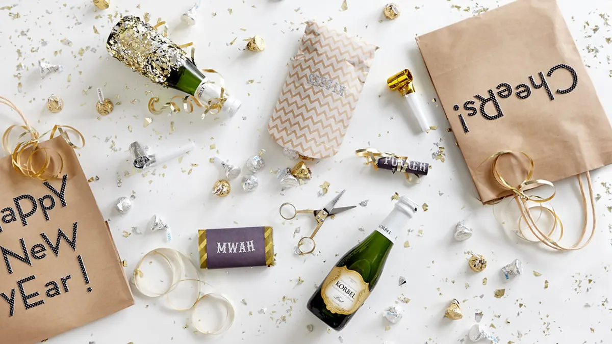 Een stapel trouwkaarten in crèmekleurige enveloppen, dichtgeplakt met ronde gouden stickers met monogram