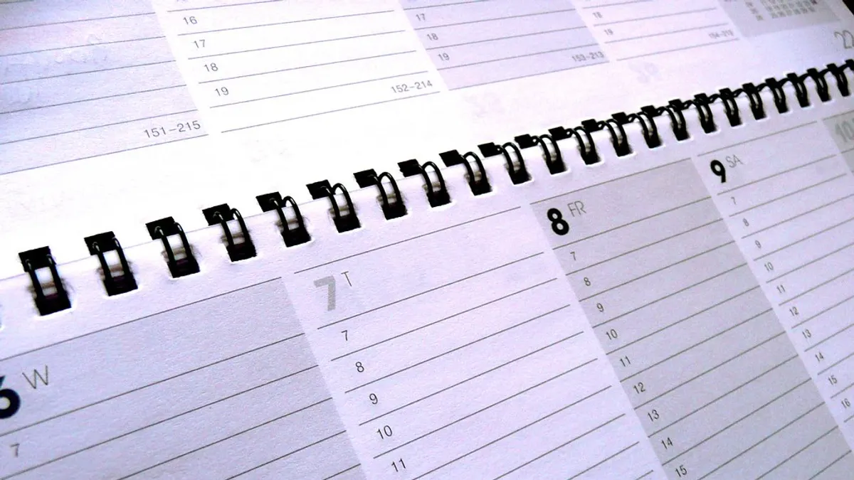 Opengeslagen agenda met ringband en lege dagvakken om de trouwplanning in te vullen