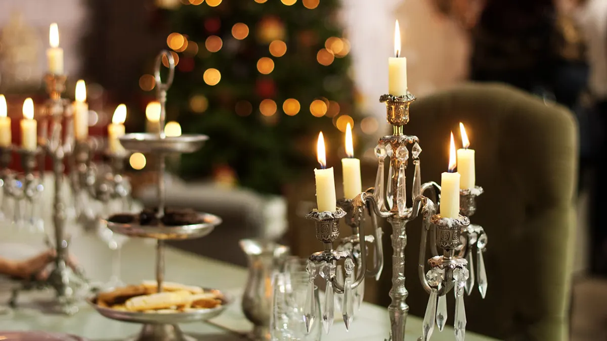 Feesttafel met brandende dinerkaarsen in zilveren kandelaars met kristallen hangers