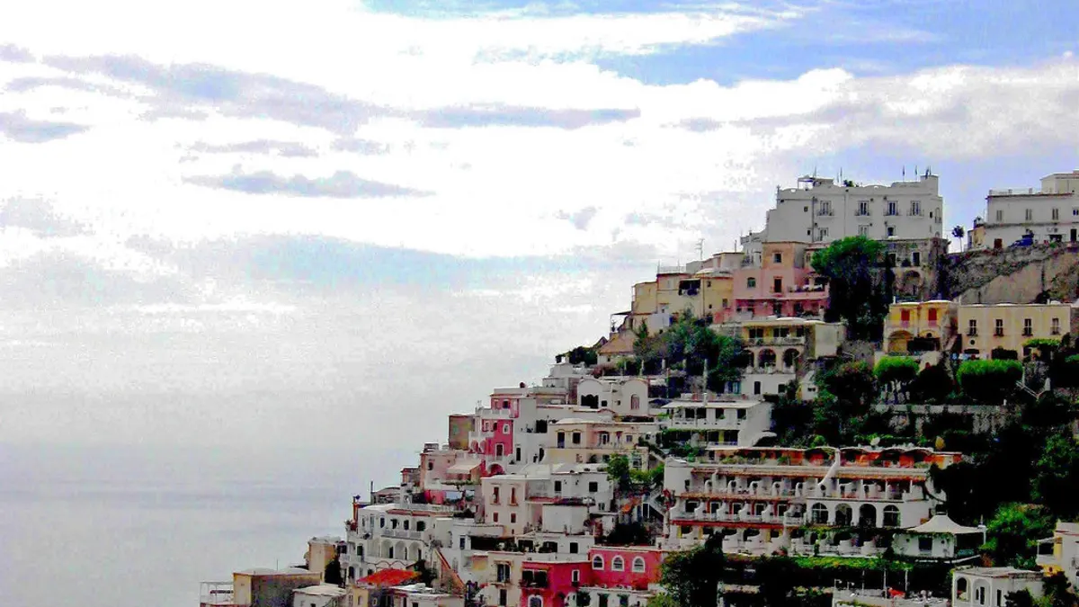 De pastelkleurige huizen van Positano die in terrassen tegen de heuvel boven de Amalfikust staan