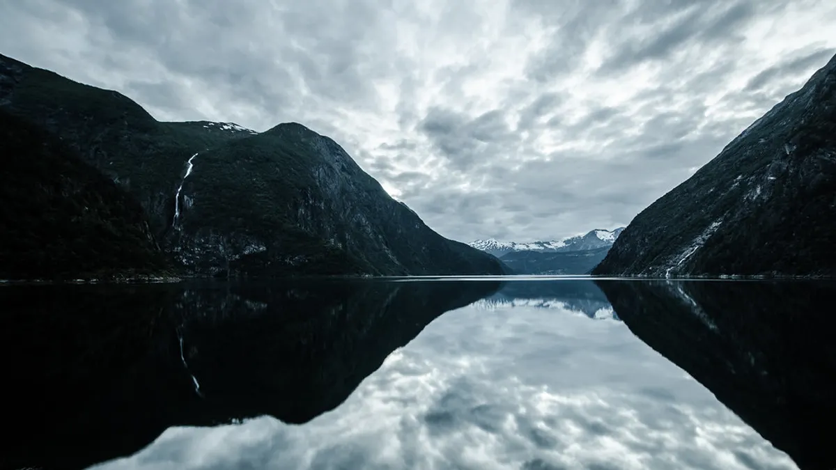 Steile bergwanden spiegelen in het stille water van de Tafjord in Noorwegen
