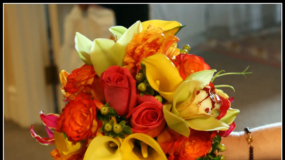 Bruidsboeket van oranje rozen, gele calla's en orchideeën