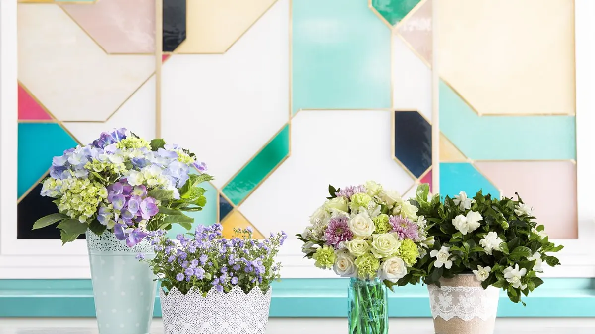 Pastelkleurige boeketten met hortensia, klokjesbloemen en witte rozen in kanten potjes en een glazen vaas