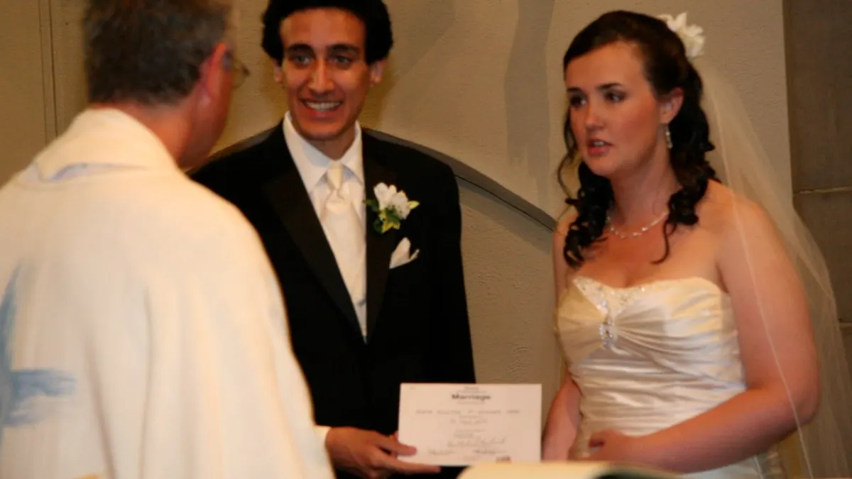 Een bruidspaar krijgt van de officiant het trouwcertificaat overhandigd