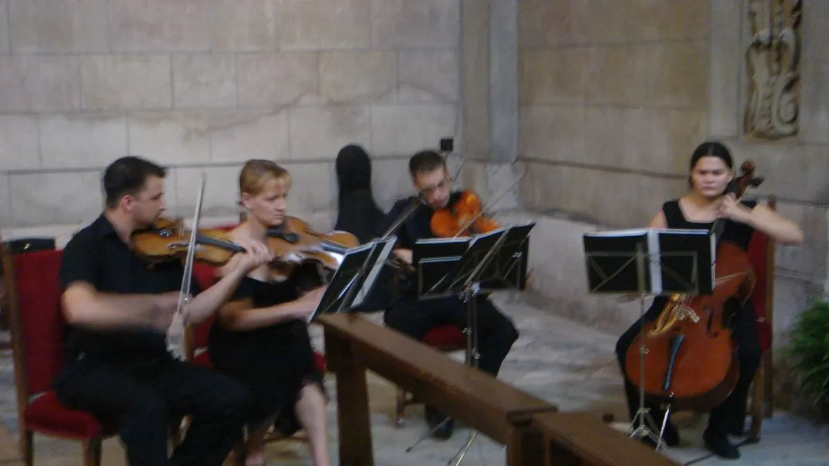 Een strijkkwartet met twee violen, altviool en cello speelt in een stenen kerk