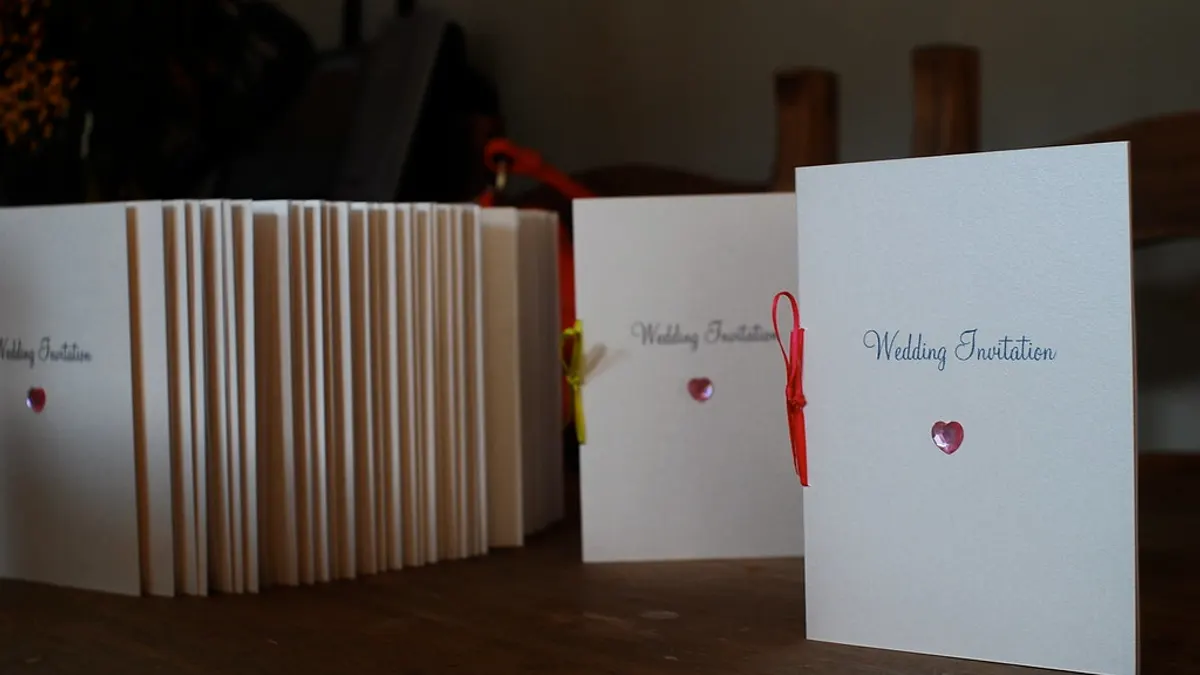 Witte trouwkaarten met een roze hartje en de tekst Wedding Invitation op een rij