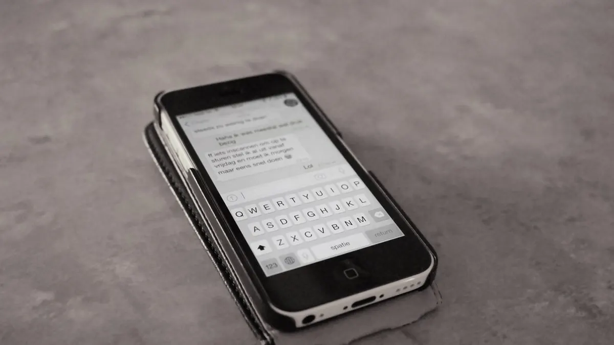 Een smartphone met een geopend chatbericht en het toetsenbord klaar om te antwoorden