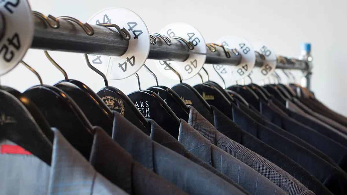 Rek met herencolberts in grijs en blauw, met maatringen van 42 tot 50 op de stang