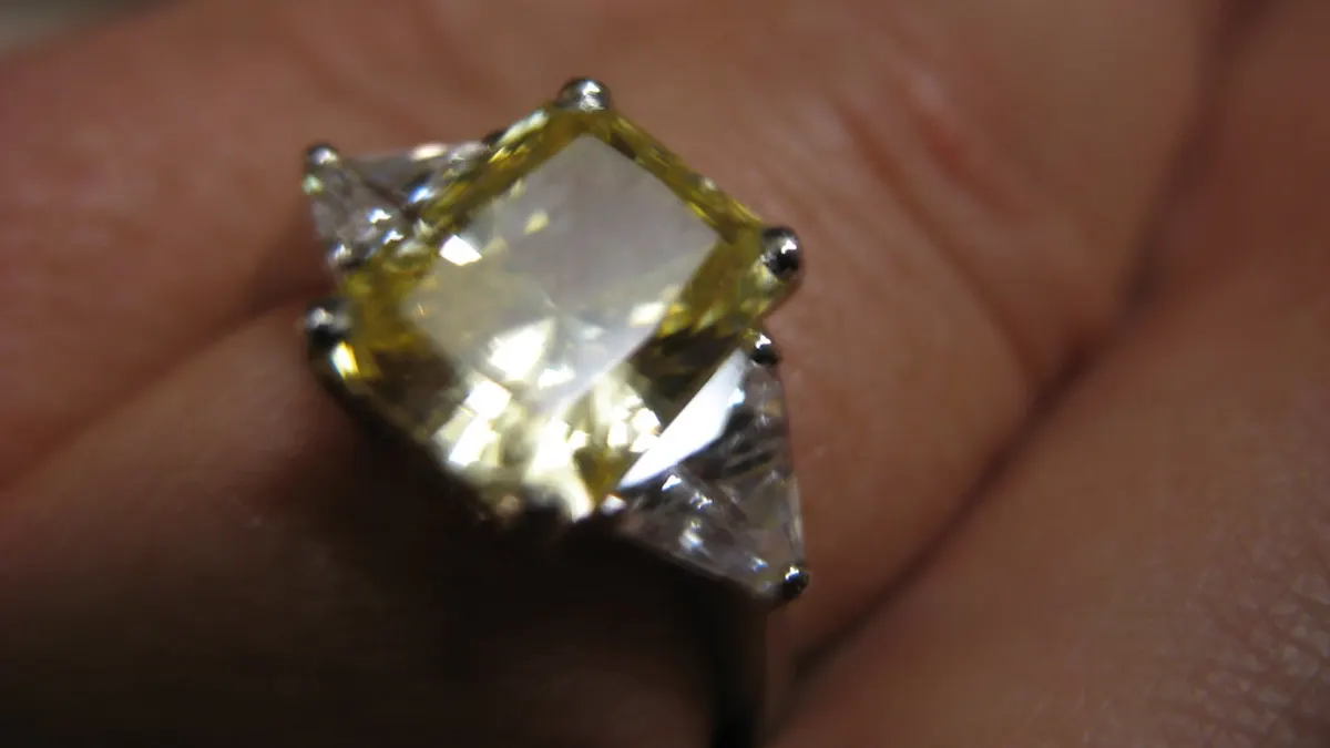 Iemand bekijkt verlovingsringen in een vitrine bij een juwelier