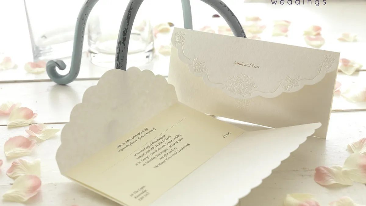 Trouwkaart met kalligrafie en envelop op een houten tafel