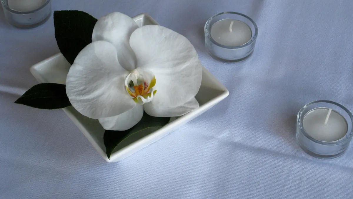 Eenvoudige zelfgemaakte tafeldecoratie met een orchidee en theelichtjes